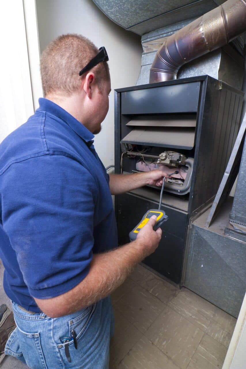 Technician operating a high-efficiency furnace system to generate reliable heat during cold winters