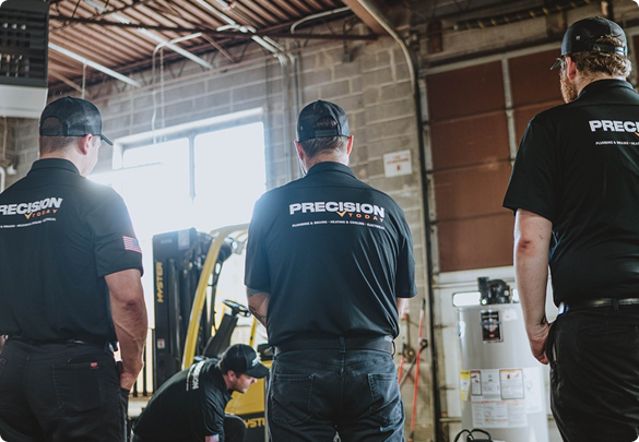 Three Precision Today apprentices watching a technician work on equipment in a training bay