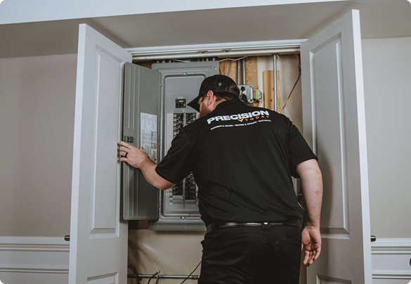 Precision Today electrician inspecting an indoor electrical panel