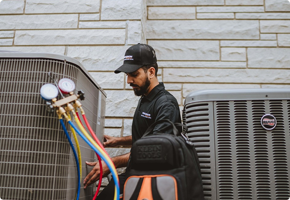 Precision Today HVAC technician connecting refrigerant gauges to an outdoor air conditioning unit