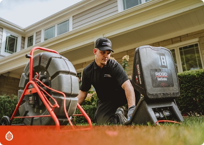 Precision Today technician operating a drain-cleaning machine outside a home